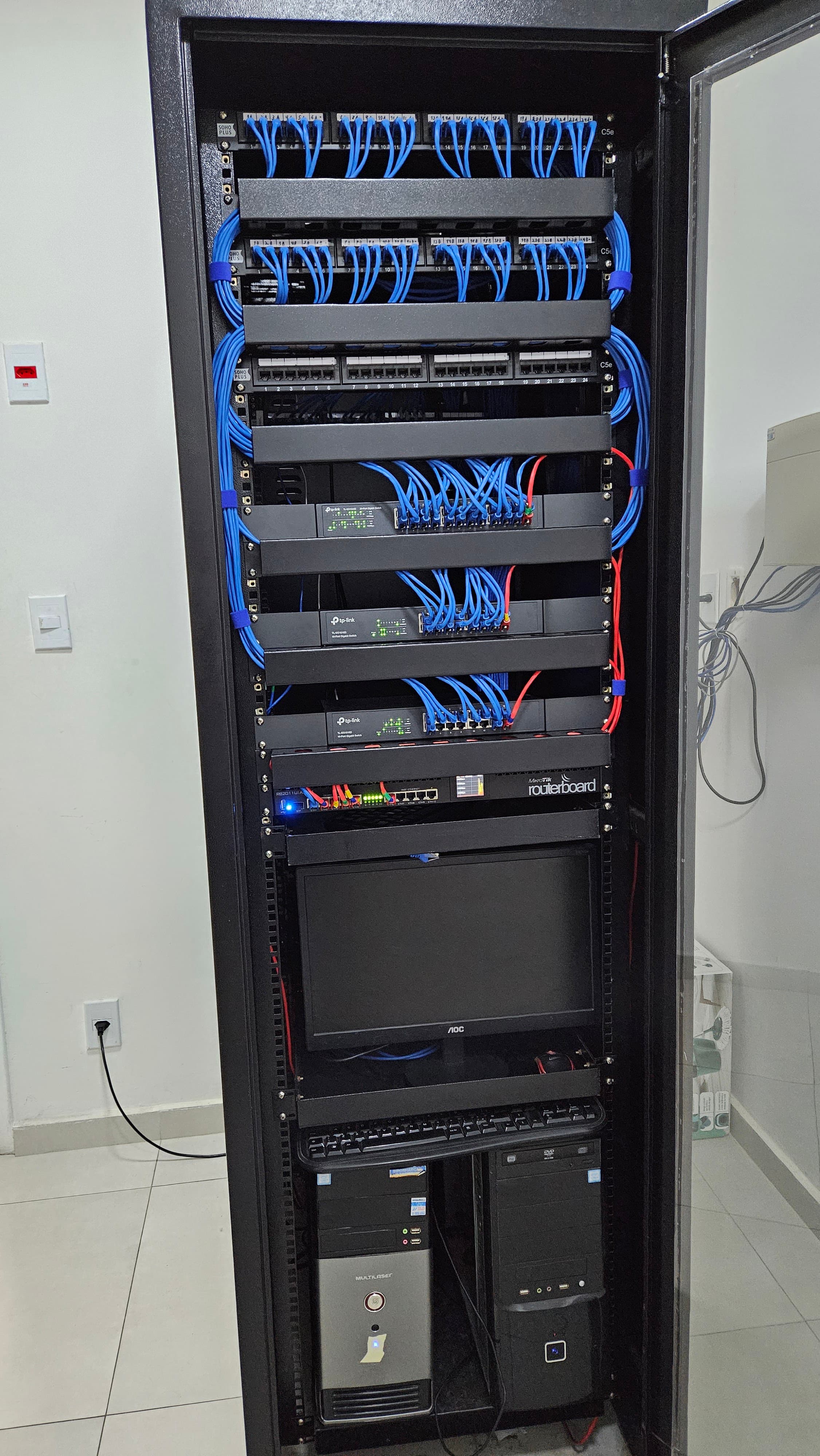Sala de equipamentos com rack completo de infraestrutura de rede corporativa montado pela Orange Digital